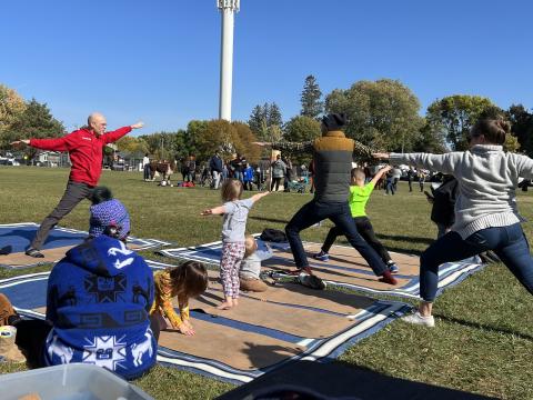 Matthew outside leading a yoga class with families