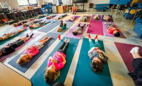 Kids lying on yoga mats in a classroom