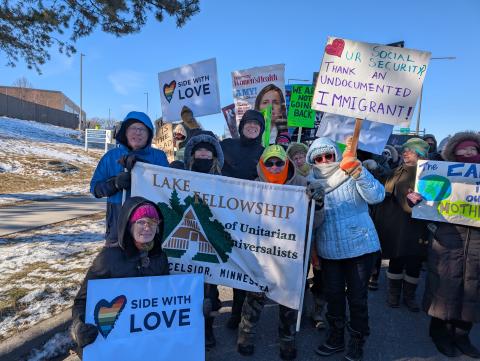 A group of people around a Lake Fellowship sign at The People's March in 2025