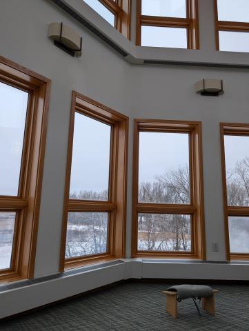 Meditation bench in a room filled with windows overlooking a marsh in the winter