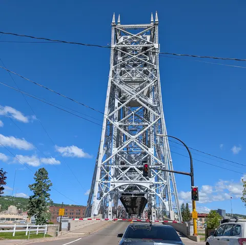 Duluth's Aerial Lift Bridge with its span raised, stopping traffic at a red light and lowered gate.