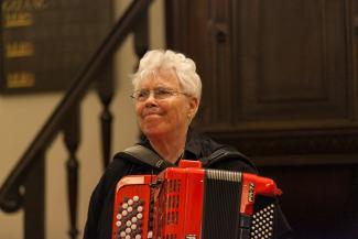 Pauline Oliveros holding a red accordion