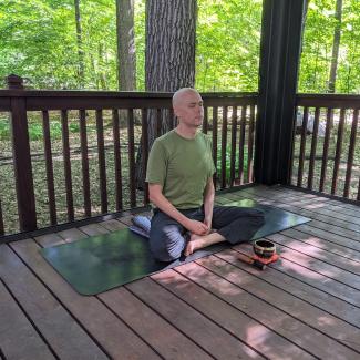 Matthew in meditation on a deck
