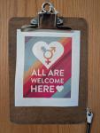 a clipboard on a door with the words all are welcome here