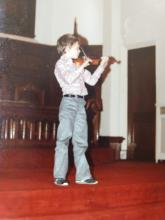 Matthew playing violin at a young age
