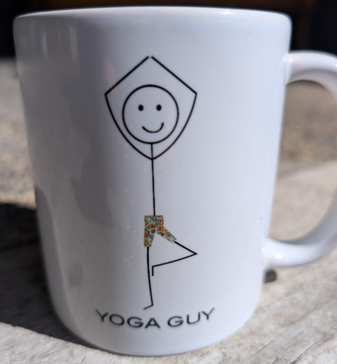 white coffee mug with the stick figure in tree pose and the words yoga guy below